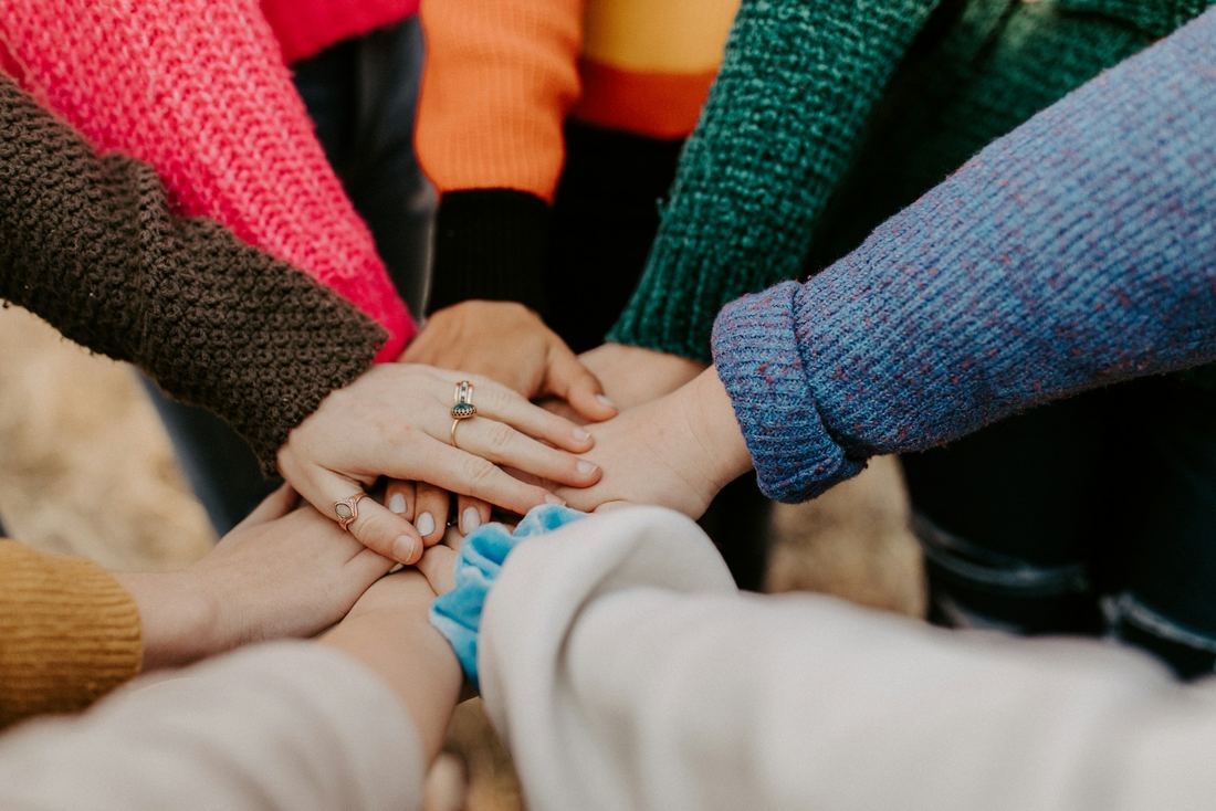 Many hands joined together in a circle